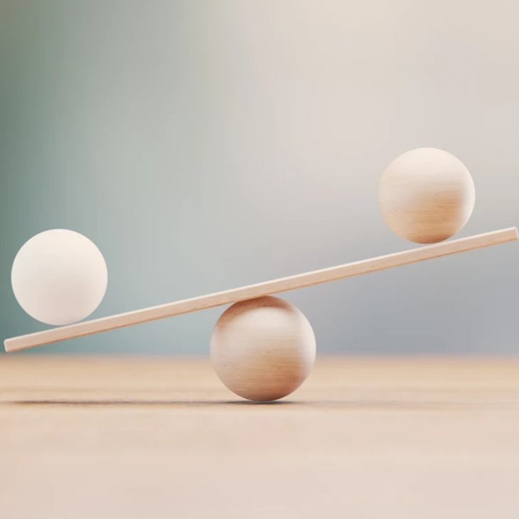 Three spheres balanced on wooden sticks in a minimalist setup.
